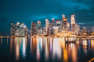 Fototapeta na wymiar SINGAPORE, SINGAPORE - MARCH 2019: Skyline of Singapore Marina Bay at night with Marina Bay sands, Art Science museum , skyscrapers and tourist boats