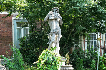 Statua di cemento con un soggetto mitologico.