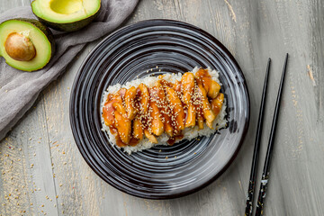 chicken in teriyaki sauce with rice on grey wooden table top view