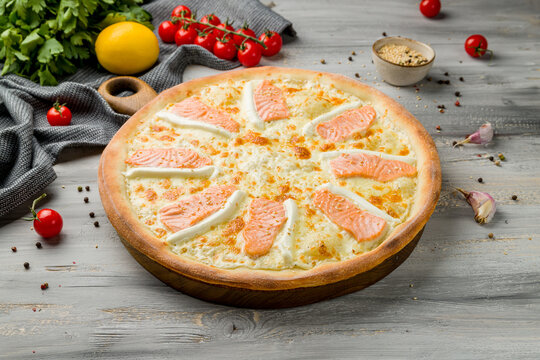 Pizza with salmon and Philadelphia cheese on grey wooden table