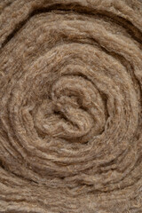 Soft eco-friendly insulating insulation in a roll of hemp and linen close-up, twisted into a roll, thermal insulation, soundproofing,  background