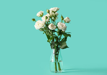 Vase with bouquet of beautiful roses on green background