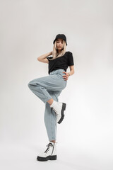 Pretty fashion blonde woman in fashionable clothes with blue jeans, t-shirt, black Panama hat and shoes poses in studio. Beauty young girl  on a white background