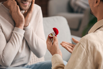 Young gay proposing to his boyfriend at home