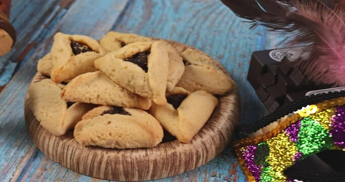Purim Jewish holiday with hamantaschen cookies hamans ears, carnival mask and parchment