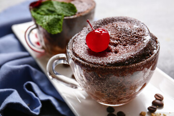 Glass cups with tasty chocolate brownie on table, closeup