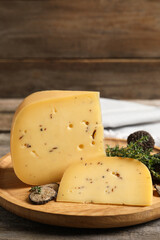 Delicious cheese, fresh black truffles and thyme on wooden table