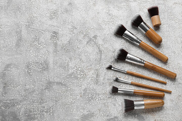 Set of beautiful makeup brushes on grey background