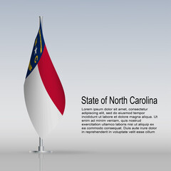 Flag of State of North Carolina (USA) hanging on a flagpole stands on the table