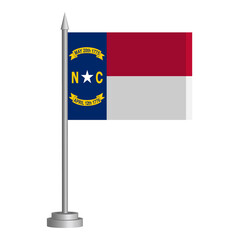 Flag of State of North Carolina (USA) flying on a flagpole stands on the table