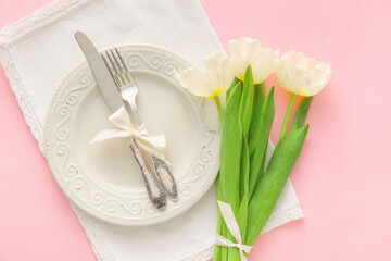 Stylish table setting with tulip flowers on pink background