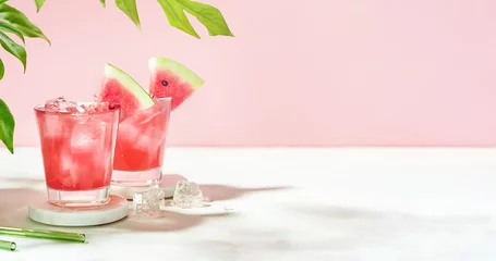Tuinposter Fresh summer cocktail watermelon juice with ice in a two glass and glass straw on pink background. Layout for wide banner with space for text. © PINKASEVICH