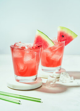 Fresh drink with watermelon and mint, cold summer lemonade, mocktail. Sunny day shadows on white background with copy space.