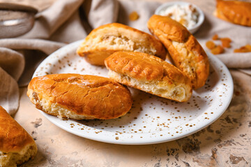 Plate of tasty sochniki with cottage cheese on beige background