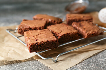Fototapeta na wymiar Grid with pieces of tasty chocolate brownie on grey background, closeup