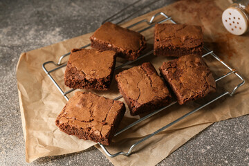 Grid with pieces of tasty chocolate brownie on grey background