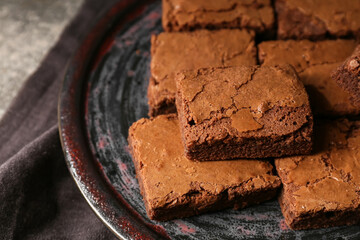 Plate with pieces of tasty chocolate brownie on table, closeup