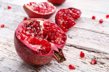 Pieces of fresh pomegranate on light wooden background