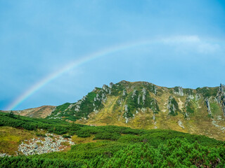 Rainbow over the rocky slopes of the Shpytsi. Mountain range of Chornohora in the Ukrainian Carpathians.
