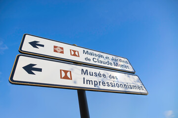 Panneau de signalisation indiquant la maison et les jardins de Claude Monet, peintre impressionniste dans le village de Giverny en France ainsi que le musée.