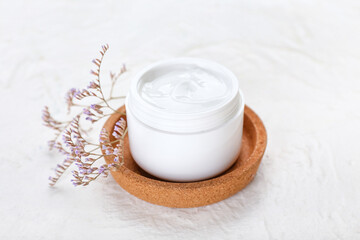 Jar with natural cosmetic cream on light background, closeup