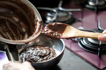 Making chocolate brigadeiro, a typical Brazilian sweet. Defocused background.