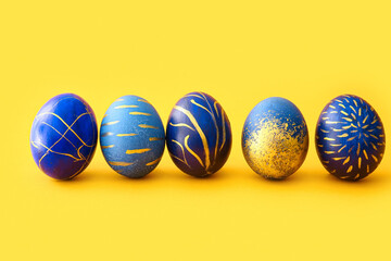 Stylish Easter eggs on yellow background