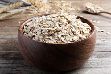 Bowl with oatmeal on wooden table, closeup