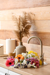 Bouquet of beautiful flowers in kitchen sink