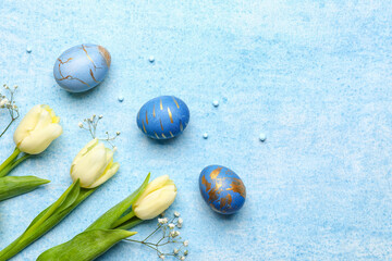 Composition with blue painted Easter eggs and flowers on color background