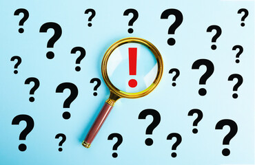Magnifying glass focused on exclamation mark between question mark. Concept of Q and A, FAQ choice...
