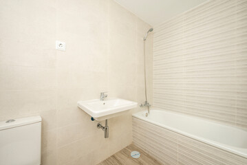 Fototapeta na wymiar Bathroom with stoic cabinetry and light cream tile and white porcelain fixtures