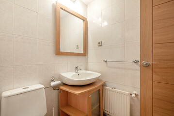 Modern bathroom with light wood cabinet and square mirror with wood frame and white china sink