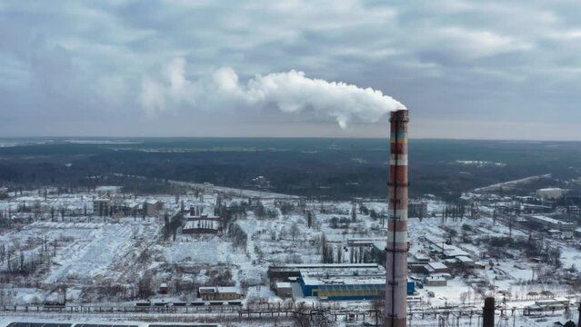 Pollution of the atmosphere by an industrial enterprise of the TPS station. Cloudy day in the winter. Smog smoke carbon and pollution emissions from industry smokestacks.  Cinematic footage