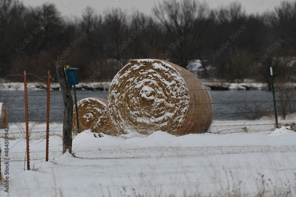 Sticker hay bale in a snowy filed