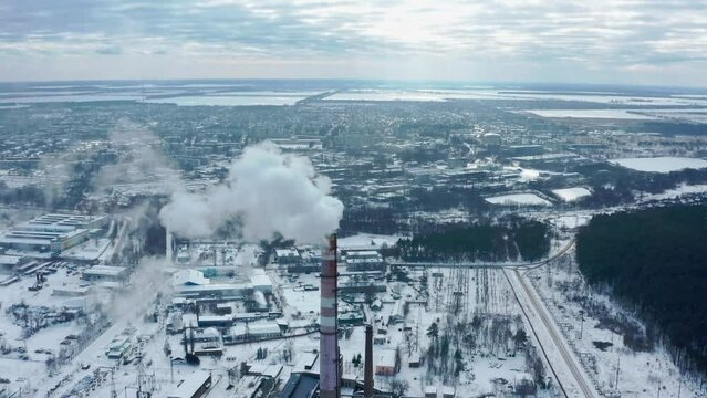 Smog smoke carbon and pollution emissions from industry smokestacks.  Cinematic footage. Pollution of the atmosphere by an industrial enterprise of the TPS station. Cloudy day in the winter.