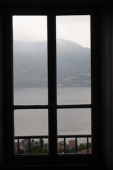 Fototapeta na wymiar Closed window with breathtaking landscape view to lake como, italy