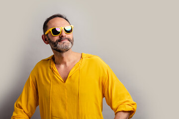 Stylish senior man wearing yellow shit and smiling
