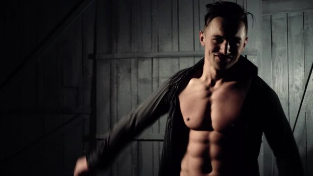 Portrait of handsome man in black shirt. Muscular man posing in studio shirtless.
