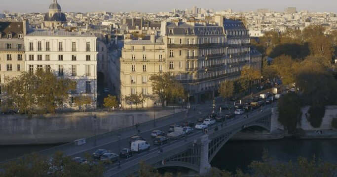 High angle time lapse of traffic and pedestrians on bridge over river autumn evening in Paris