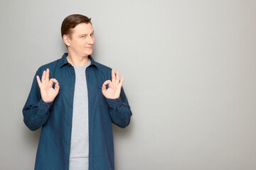 Portrait of confident mature man showing okay gestures and smiling