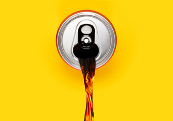 Cola soda can pouring out. Spilling energy or soft drink out of can on isolated yellow background....