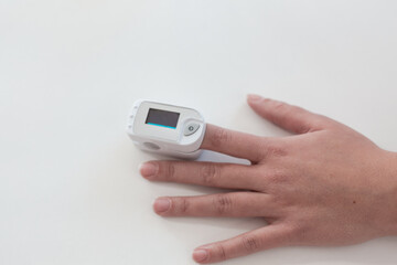 Pulse oximeter on a woman's finger. blood oxygen saturation. The patient measures the saturation of the blood with an electronic pulse oximeter on the finger - 484522524