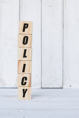 wooden cube, with the word policy, with white wooden background