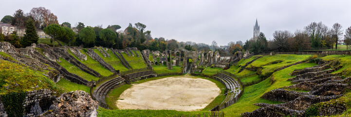 Saintes, Charente Maritime, France. The Ruins Gallo-Roman Amphitheatre of Mediolanum Santonum. Saint Eutrope church listed as World Heritage by UNESCO the arenas in the background.