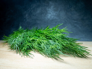 A bunch of dill on a cutting board. Useful product. Greens on the kitchen table. Vegetarian lunch ingredient.