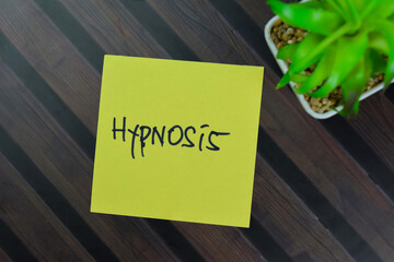 Hypnosis write on sticky notes isolated on Wooden Table.
