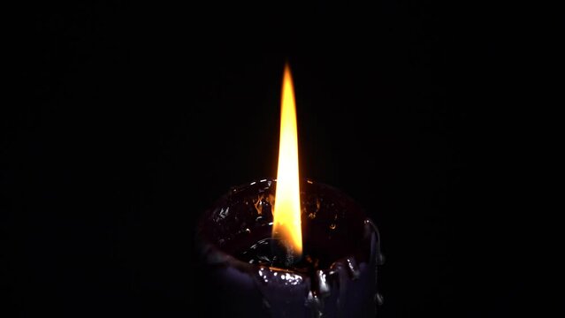Black candle selective focus. Witchcraft altar for satanic rituals. Dark background for performing mystical esoteric ritual. Macabre and witch spells darkness for Halloween concept.