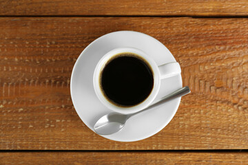 Cup of tasty coffee on wooden table, top view