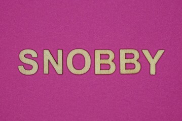 Fototapeta na wymiar word snobby in small wooden letters with violet background